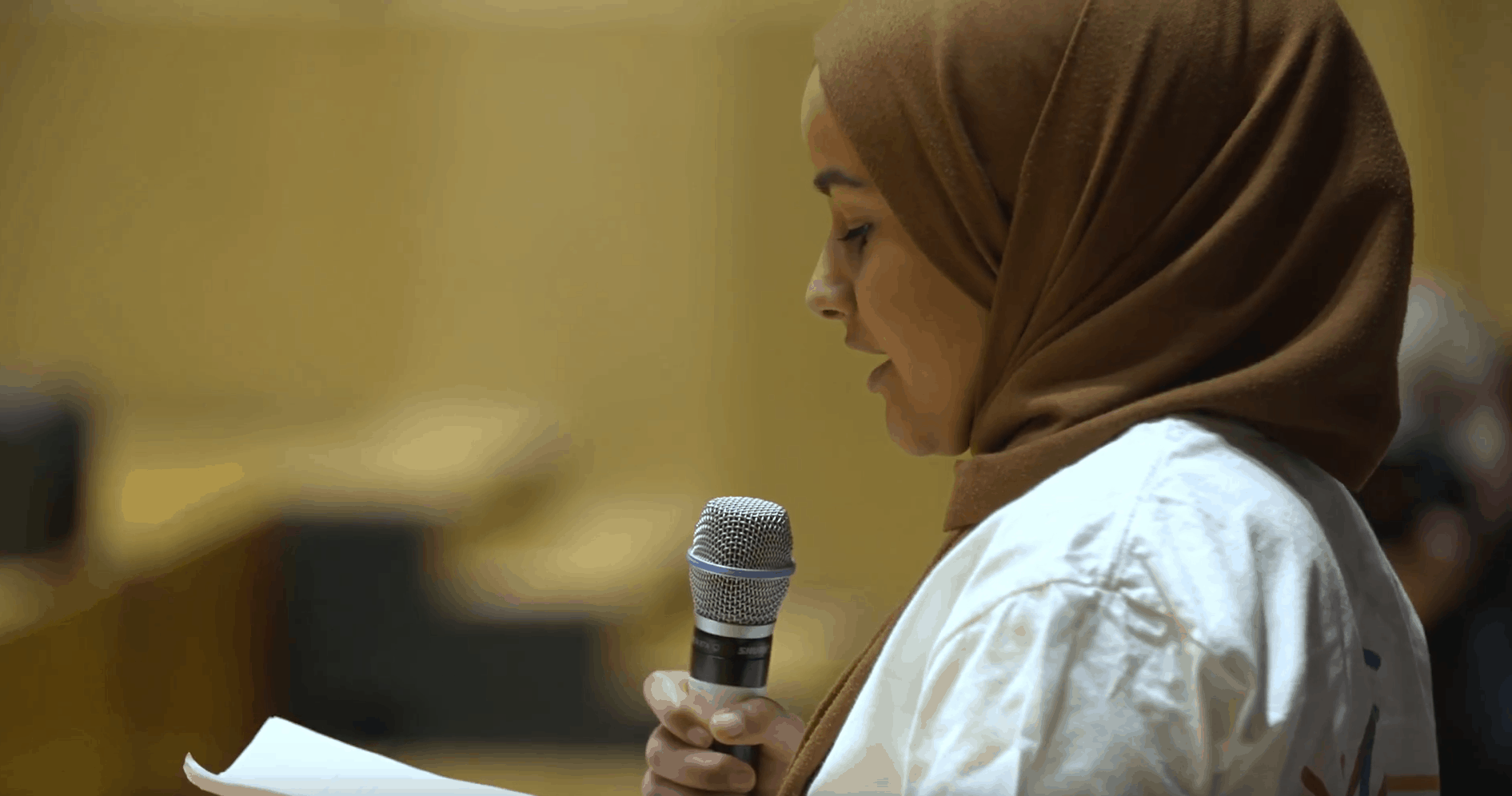Screen shot of female young person talking on stage