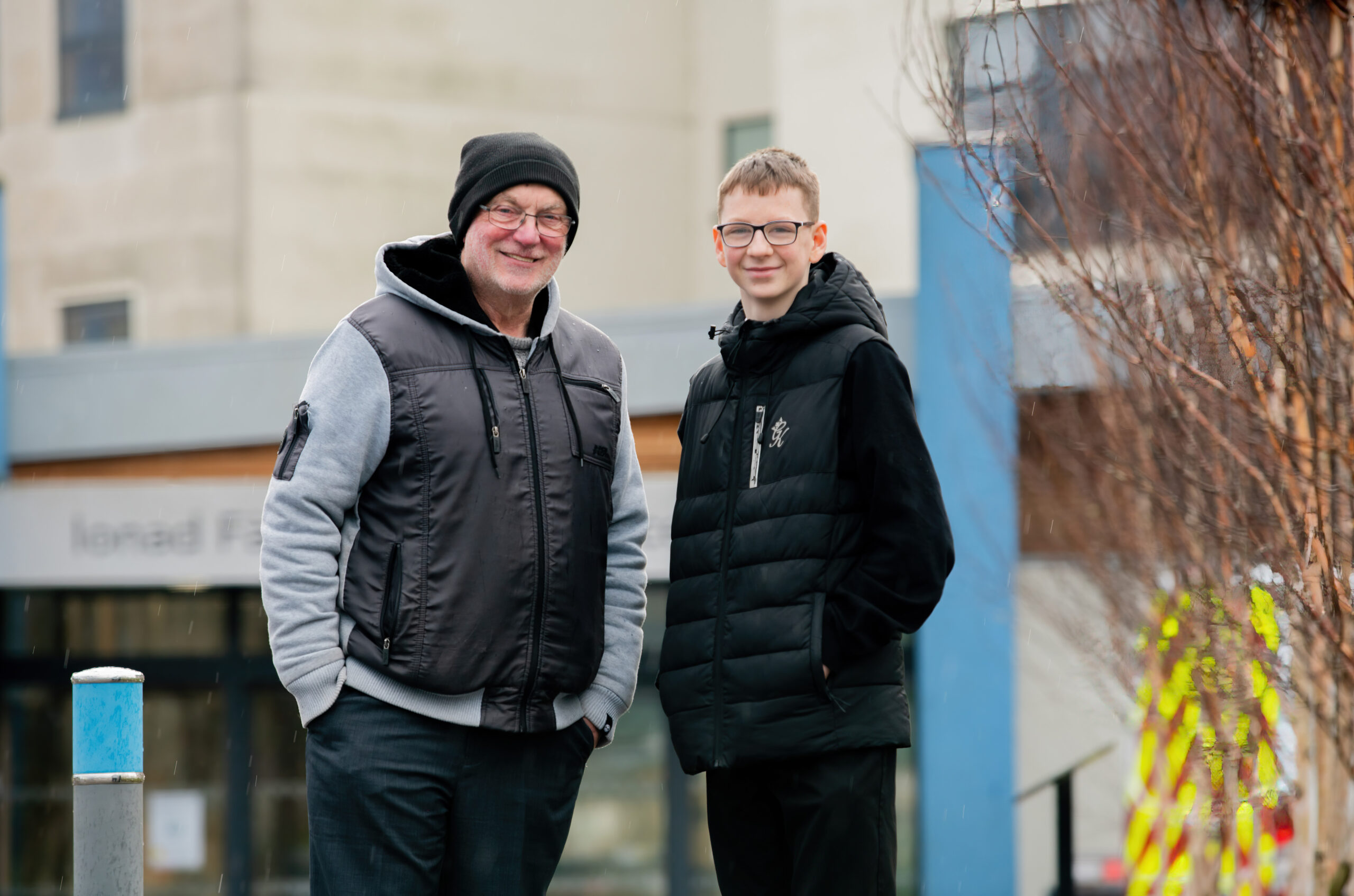A picture of a mentor and mentee standing outside a school.