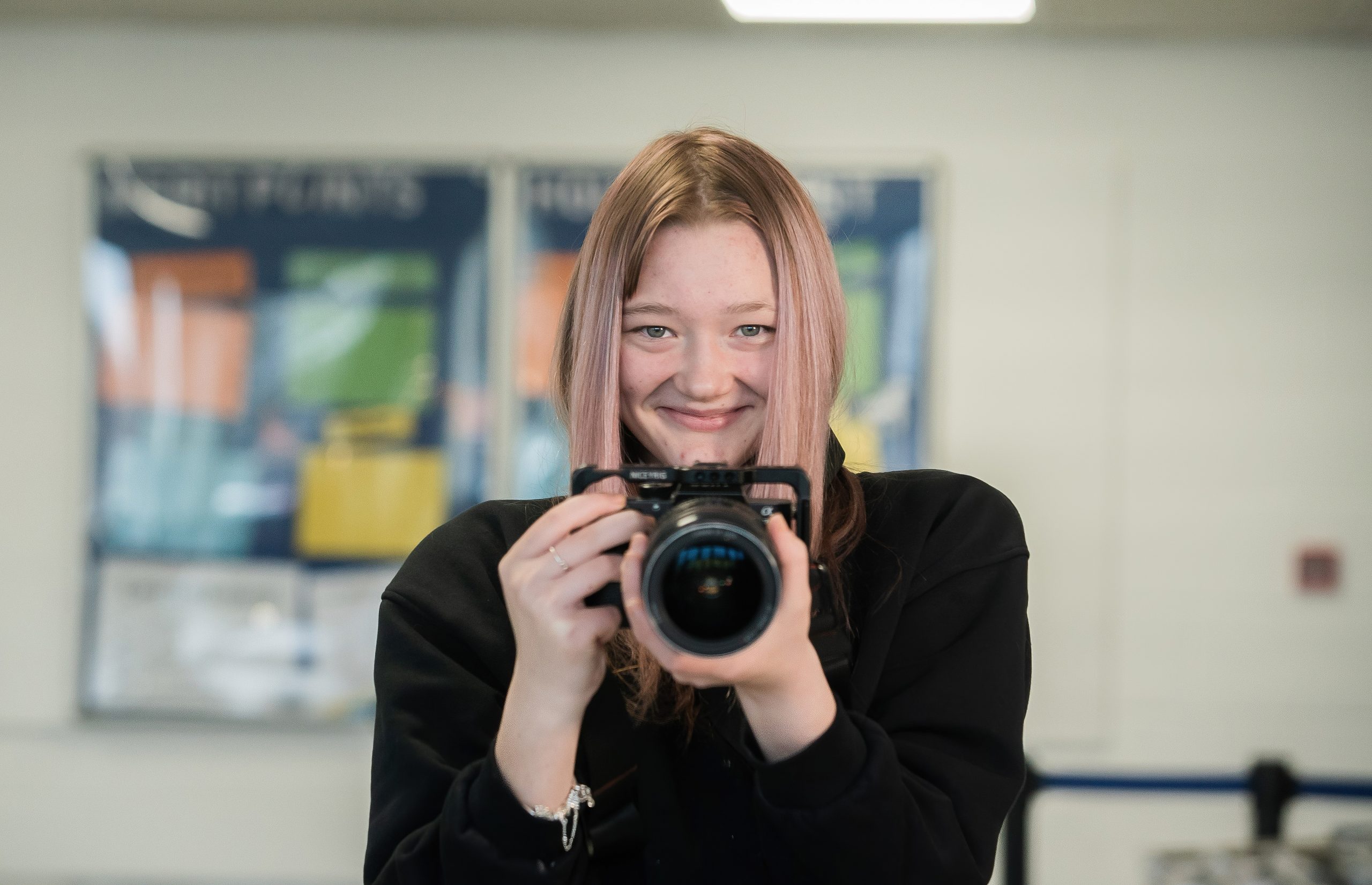 Person smiling while holding a camera