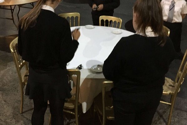 Young people setting table on a hospitality talent taster